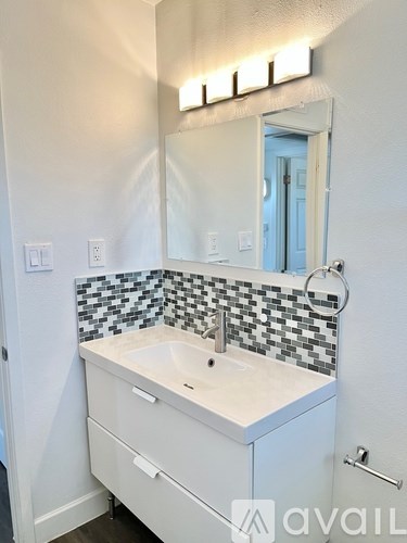 A bathroom with a sink and a mirror above it.