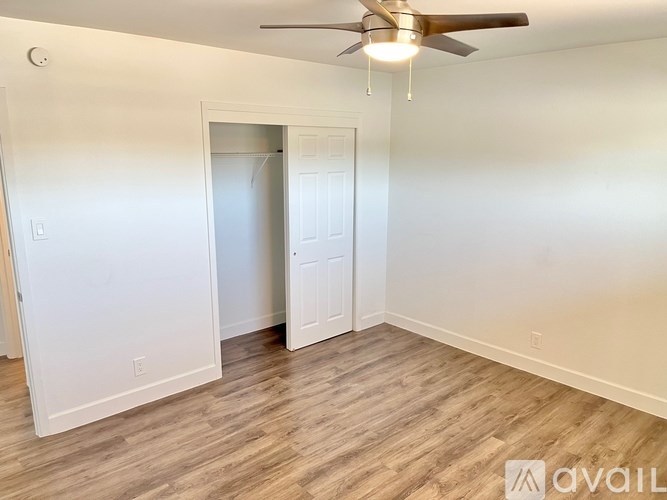 A room with a ceiling fan and two doors.