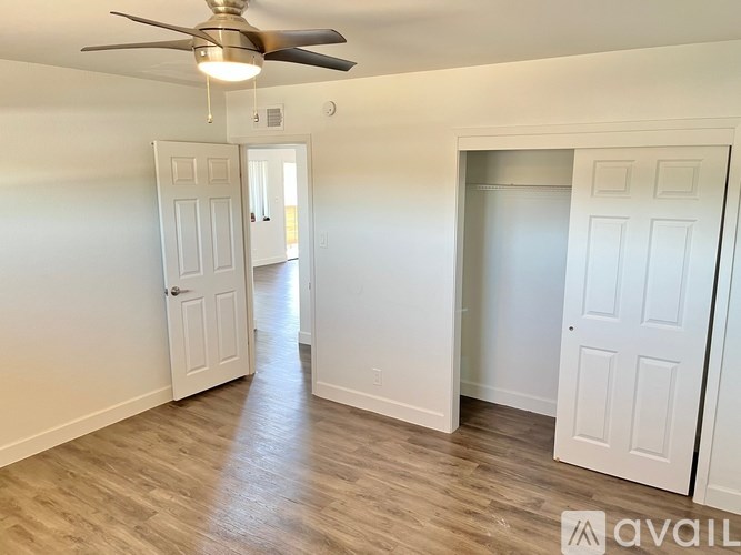 A room with a ceiling fan and two doors.