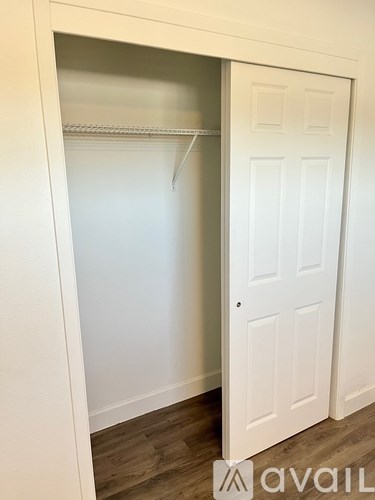 A white door is open to a white closet.