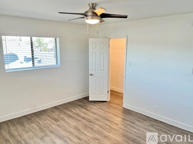A room with a ceiling fan and a door.