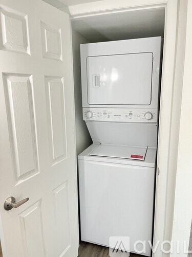 A white washing machine and dryer in a small closet.