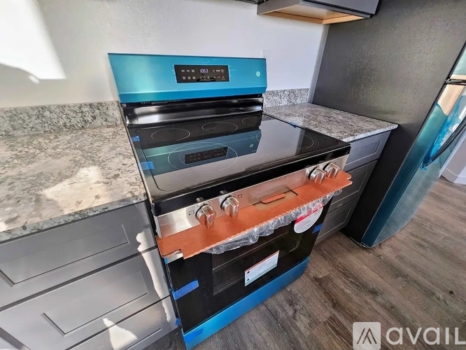 A modern kitchen with a black and blue stove top oven.