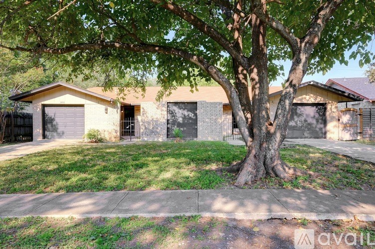 A tree in front of a house with a sign that says "avail".