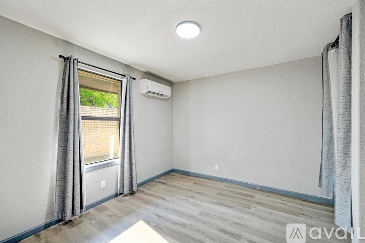 A room with a window and a wall-mounted air conditioner.