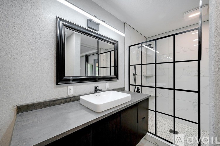 A modern bathroom with a white sink and a large mirror.