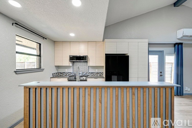 A kitchen with a wooden counter and a black oven.