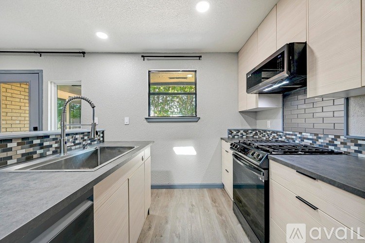 A kitchen with a black stove top oven and a window.