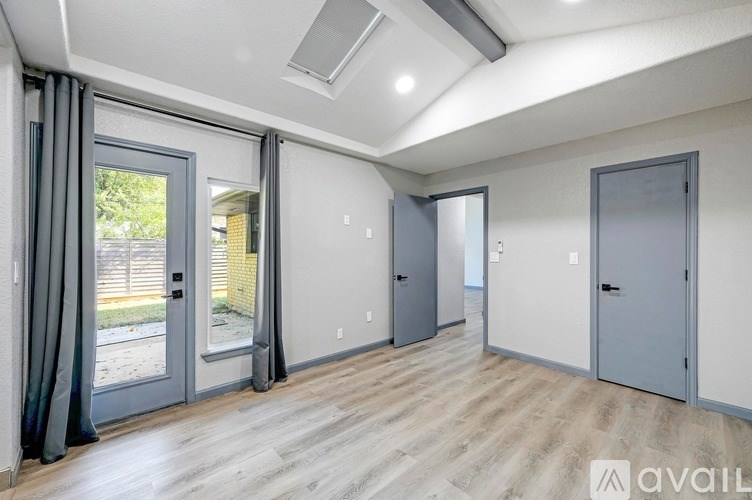 A room with a sliding glass door and wooden flooring.