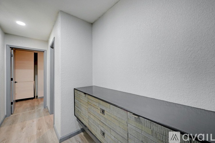 A hallway with a door and a counter.