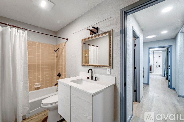 A bathroom with a white sink and a white toilet.