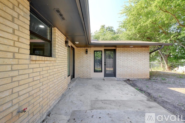 A house with a brick exterior and a concrete driveway.