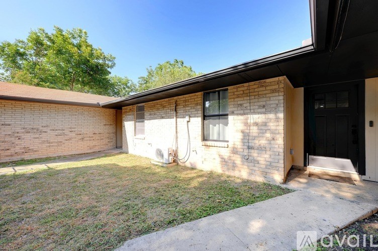 A house with a black door and a window is for sale.