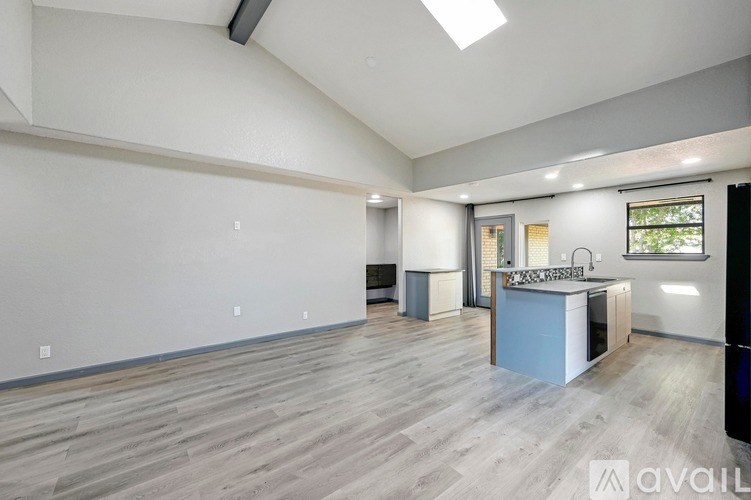 A spacious room with a kitchenette and a window.