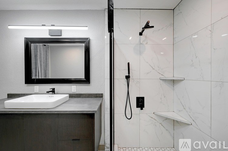 A bathroom with a marble wall and a white sink.