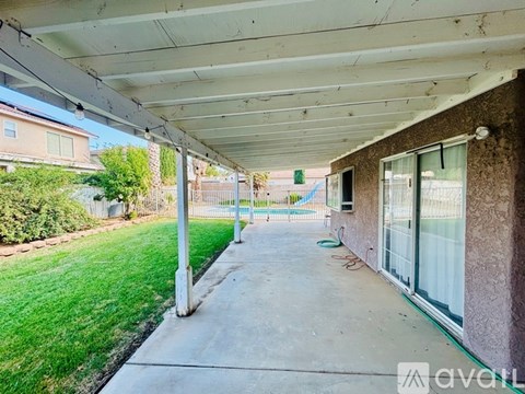 A covered walkway leads to a building with a green sign in the background.