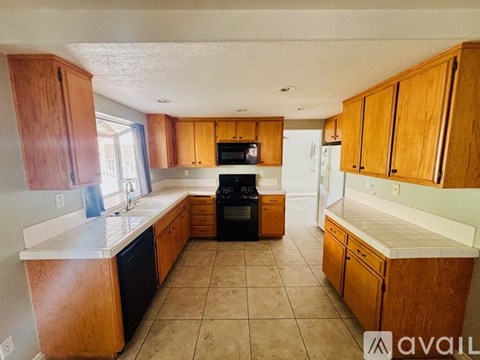 A kitchen with wooden cabinets and a black oven.