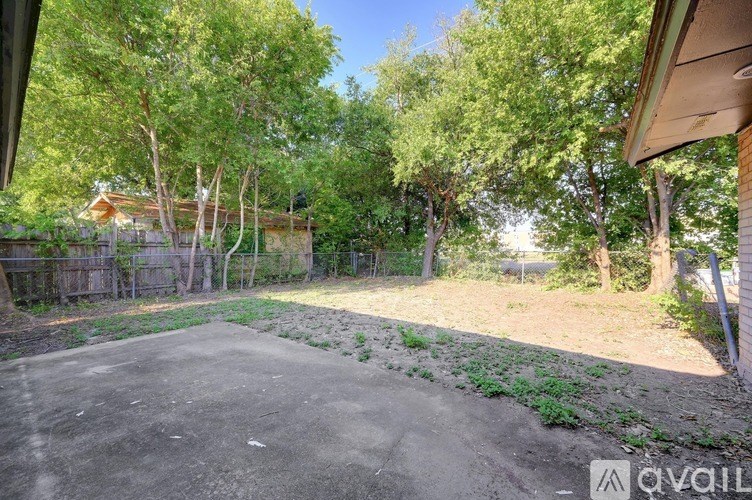 A backyard with a concrete slab and trees.