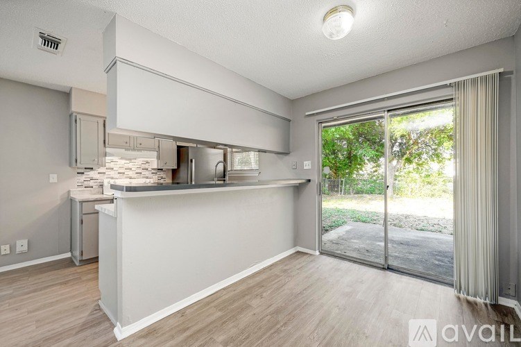 A kitchen area with a counter and a window with a view of the outside.