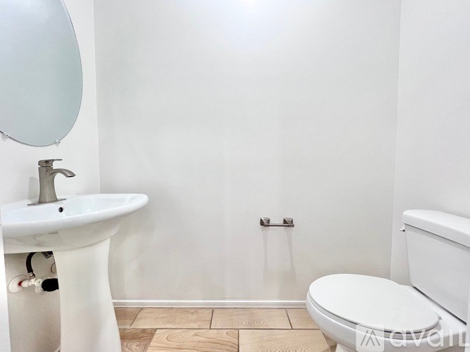 A white bathroom with a sink, toilet and mirror.