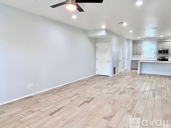 A spacious room with a ceiling fan and lighting fixtures.