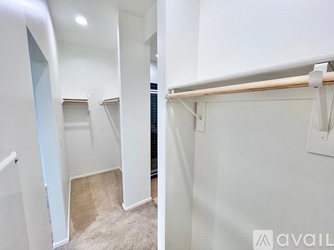 A white wall with a wooden beam and a white door.