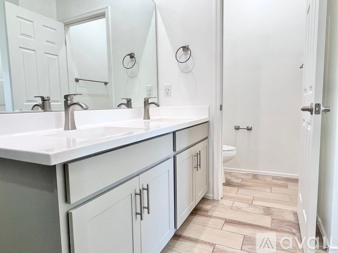 A bathroom with a white sink and a white door.