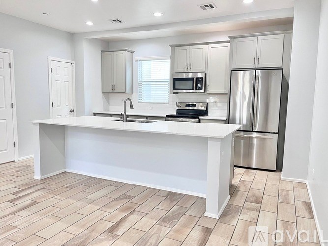 A kitchen with a white countertop and stainless steel appliances.