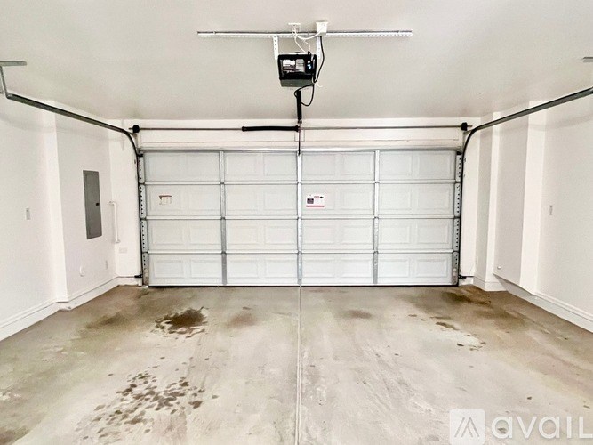 A garage with a white door and a ceiling fan.