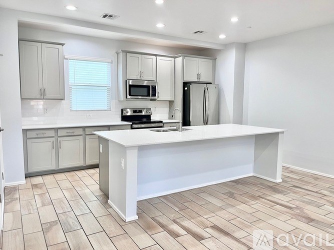 A kitchen with a white island and a refrigerator.