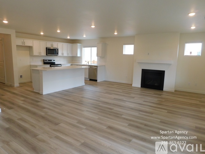 A spartan agency office with a fireplace and wood flooring.