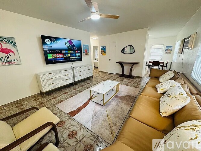 A living room with a flat screen TV mounted on the wall.