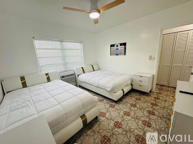 A bedroom with two beds and a ceiling fan.