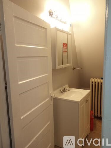 A small white bathroom with a sink and a radiator.