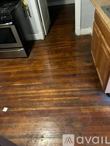A kitchen with a wooden floor and a white oven.