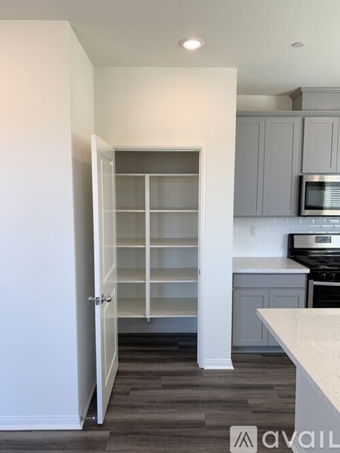 A kitchen with a white counter top and a white door.