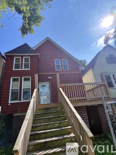 A red house with a wooden staircase leading to the front door.