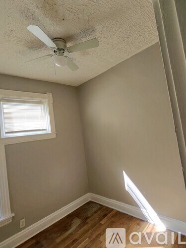 A room with a ceiling fan and a window.