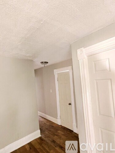 A room with a white door and a white wall.