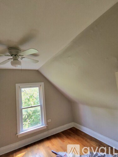 A room with a ceiling fan and a window.