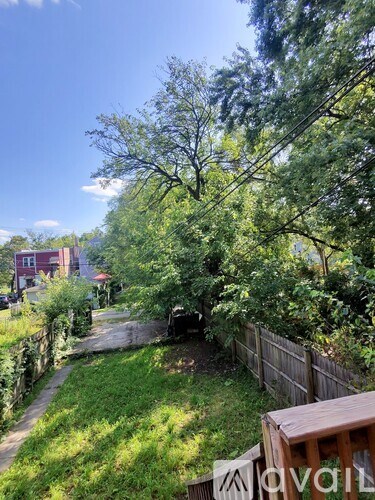 A backyard with a wooden deck and a fence.