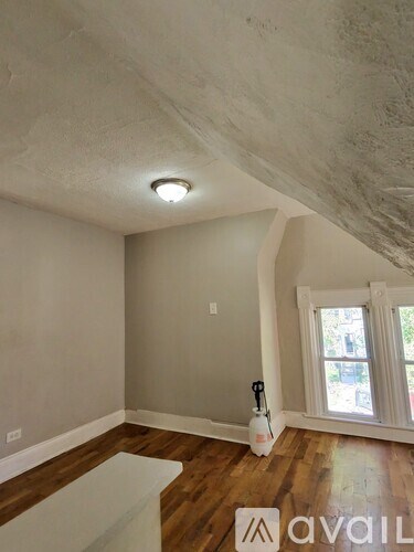 A room with a window and a vacuum cleaner on the floor.