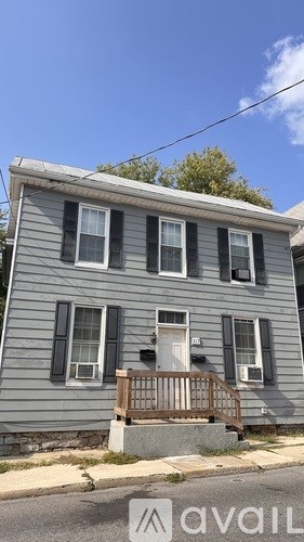 A two-story house with a porch and a garage door.
