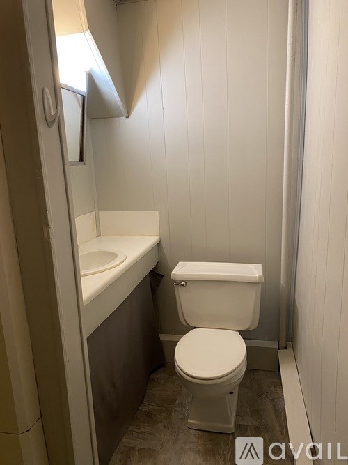 A white toilet sits next to a white sink in a small bathroom.