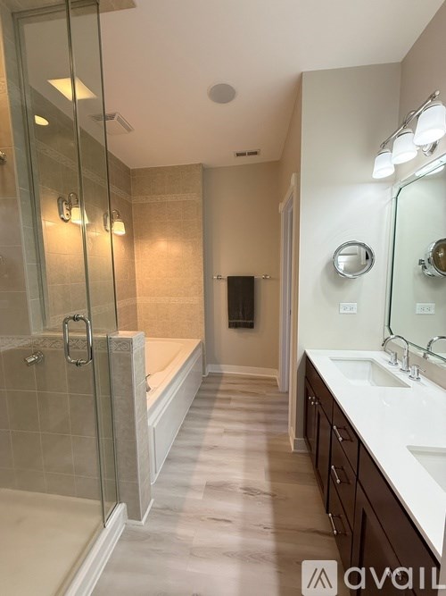 A bathroom with a walk-in shower and double sinks.