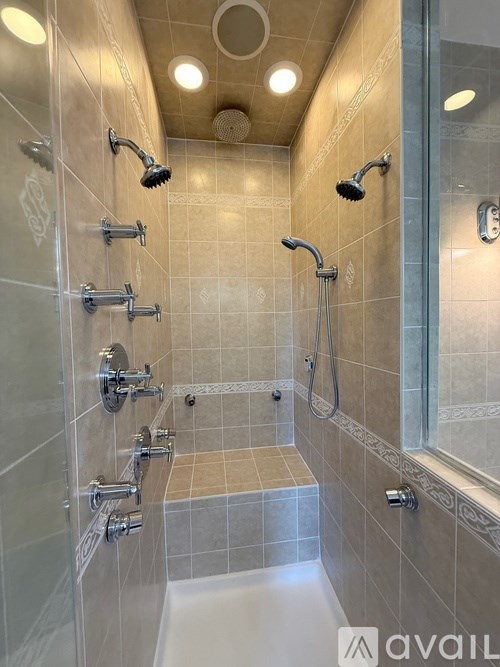 A shower area with a glass door and a glass shower head.