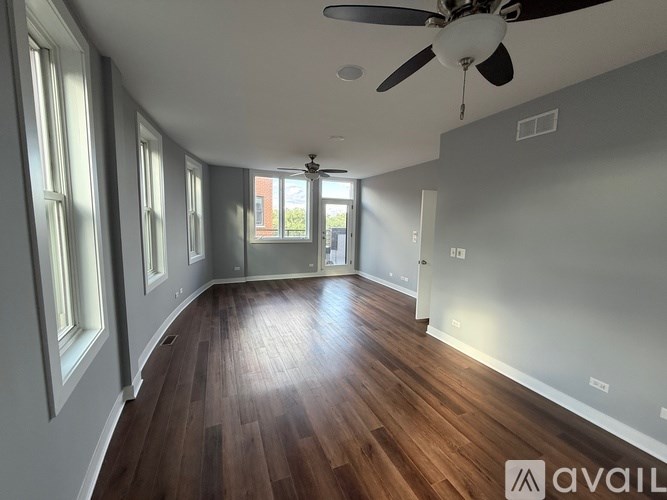 A room with wooden floors and a ceiling fan.