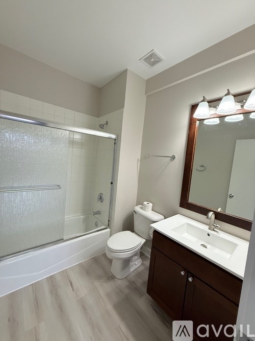 A bathroom with a toilet, sink, and shower.