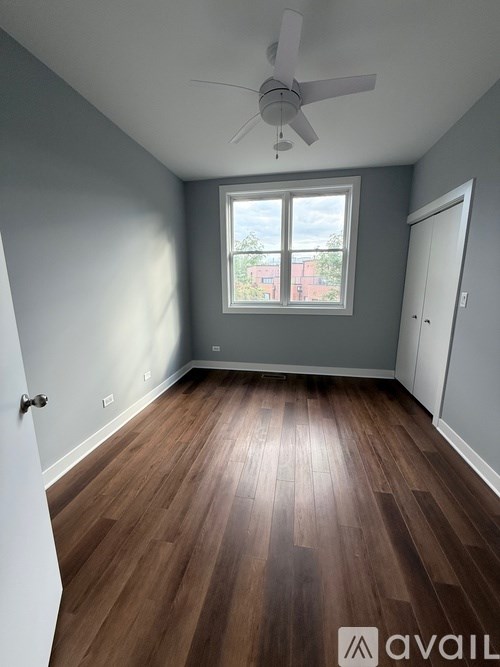 A room with a ceiling fan and wooden flooring.