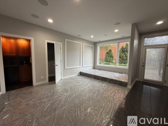 A room with a large window, a door, and a wall with a window.